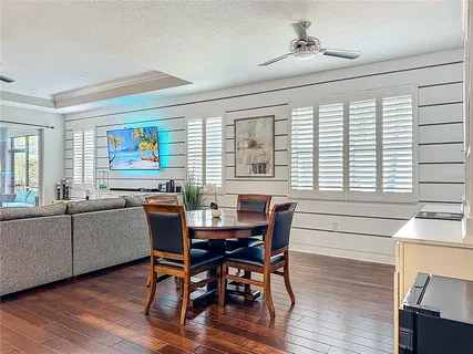 a view of a a dining room with furniture window and wooden floor
