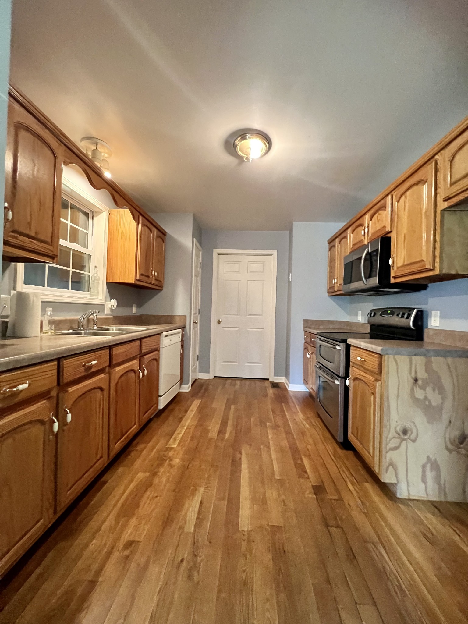 12480 Owens Chapel Road Springfield, TN 37172 - Photo 8 of 36 a large kitchen with stainless steel appliances granite countertop a large stove a sink dishwasher and microwave with wooden floor