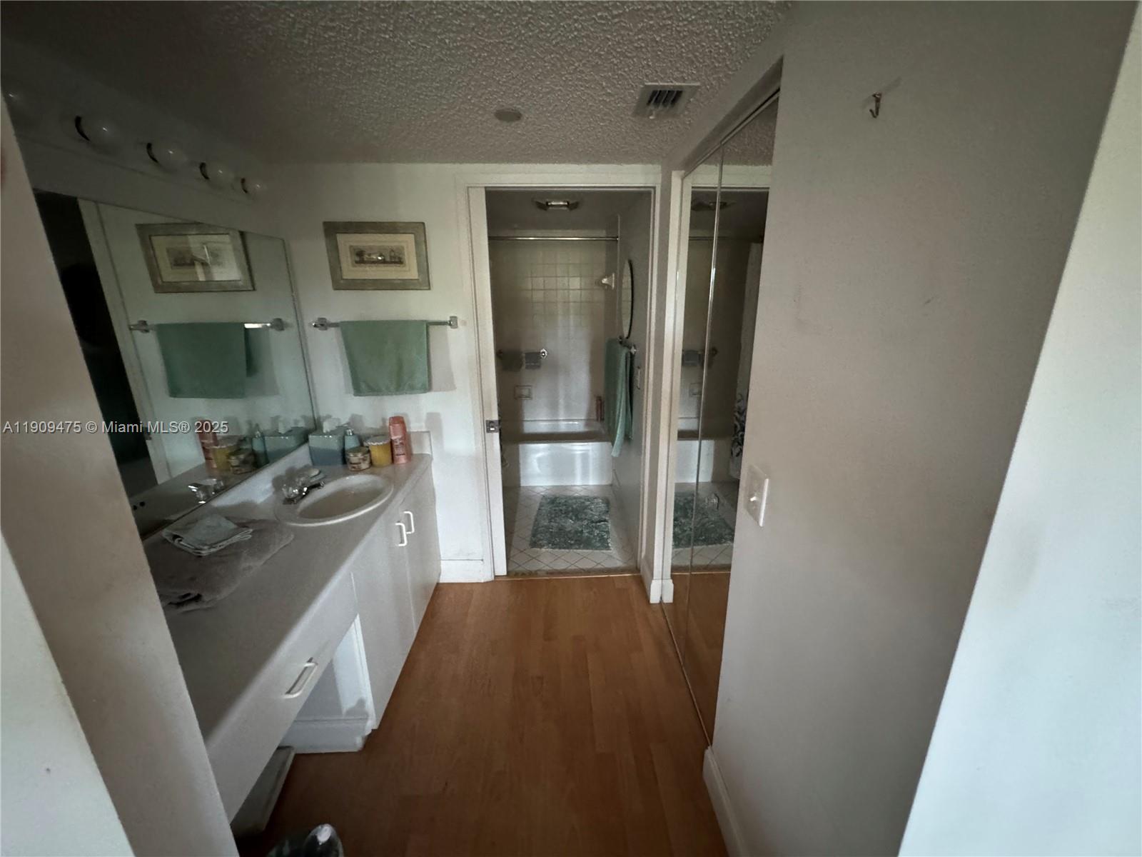 1650 Southwest 124th Terrace, Unit 403D Pembroke Pines, FL 33027 - Photo 10 of 11 a bathroom with a sink a mirror and a shower