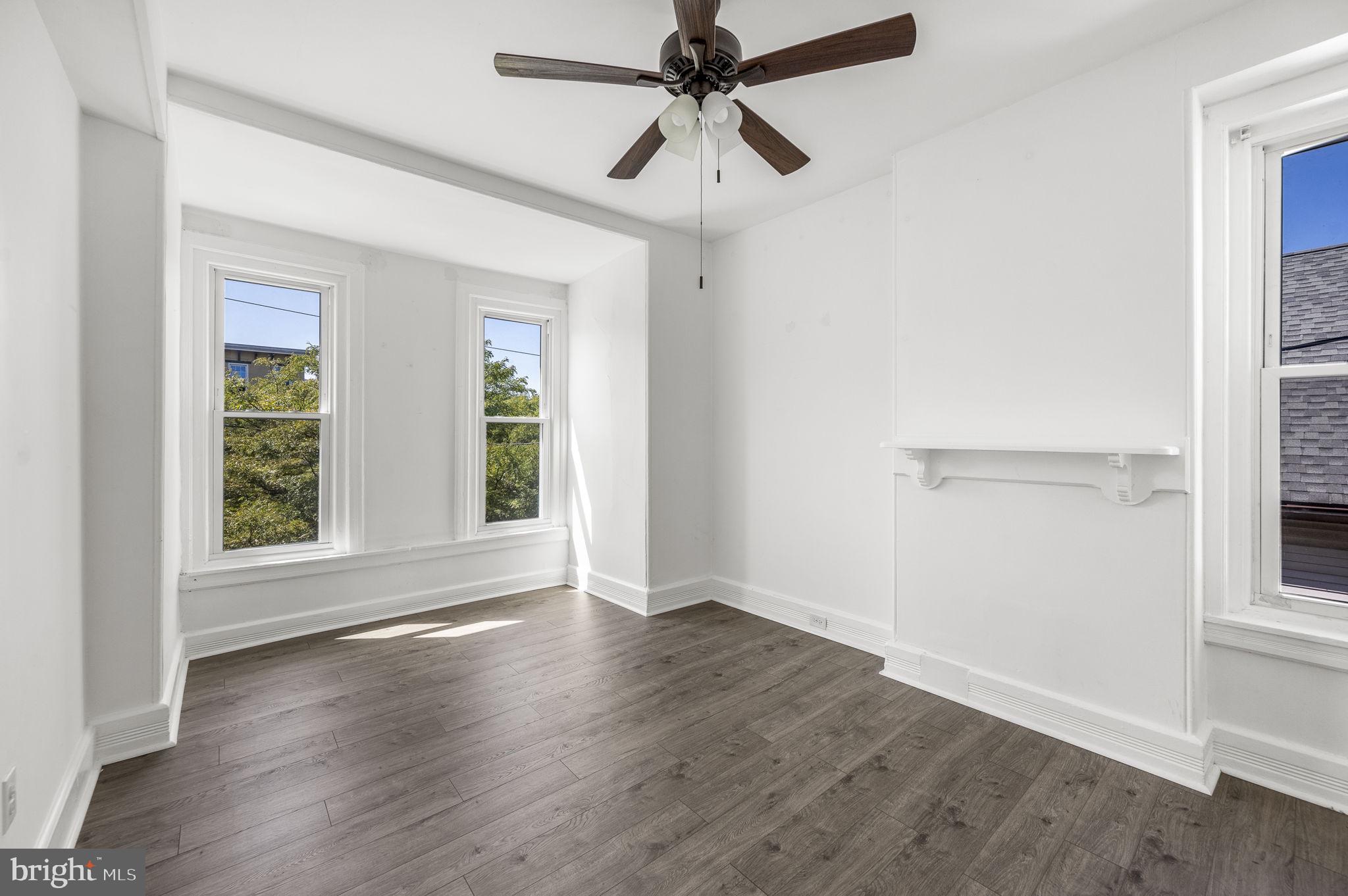 303 South Main Street, Unit 2 Phoenixville, PA 19460 - Photo 13 of 24 an empty room with wooden floor fan and windows