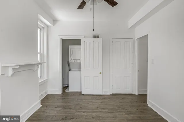 a view of an empty room with chandelier fan