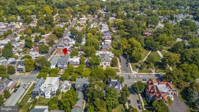 an aerial view of residential houses with outdoor space and trees