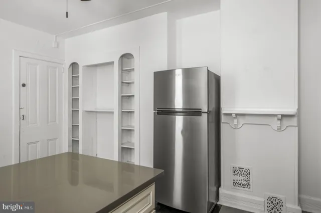 a kitchen with a refrigerator and cabinets