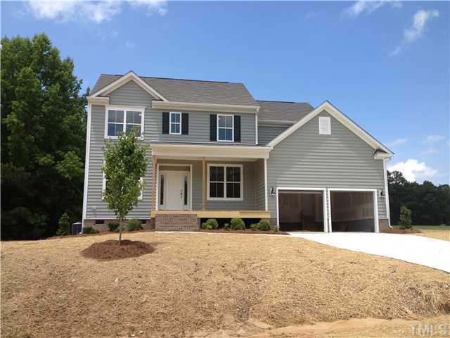 1104 Farmers Branch Road Willow Spring, NC 27592 - Photo 1 of 16 a front view of a house with a yard and garage