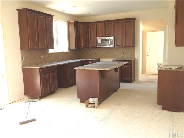 1104 Farmers Branch Road Willow Spring, NC 27592 - Photo 3 of 16 a kitchen with stainless steel appliances granite countertop a stove a sink and a microwave