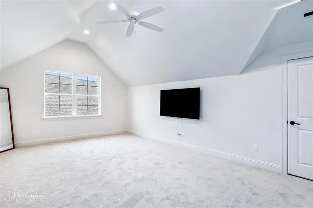an empty room with windows and flat screen tv