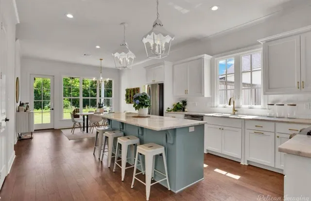 a kitchen with stainless steel appliances granite countertop wooden floor and large windows