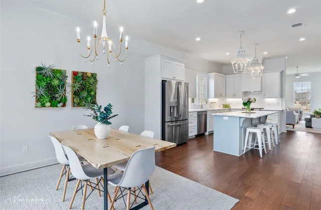 a view of a dining room with furniture a chandelier and wooden floor
