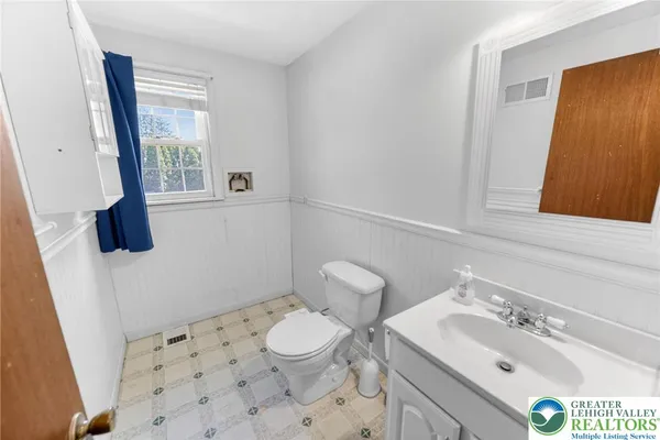 a bathroom with a sink a toilet a window and mirror