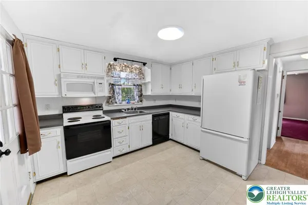 a kitchen with white cabinets and white appliances