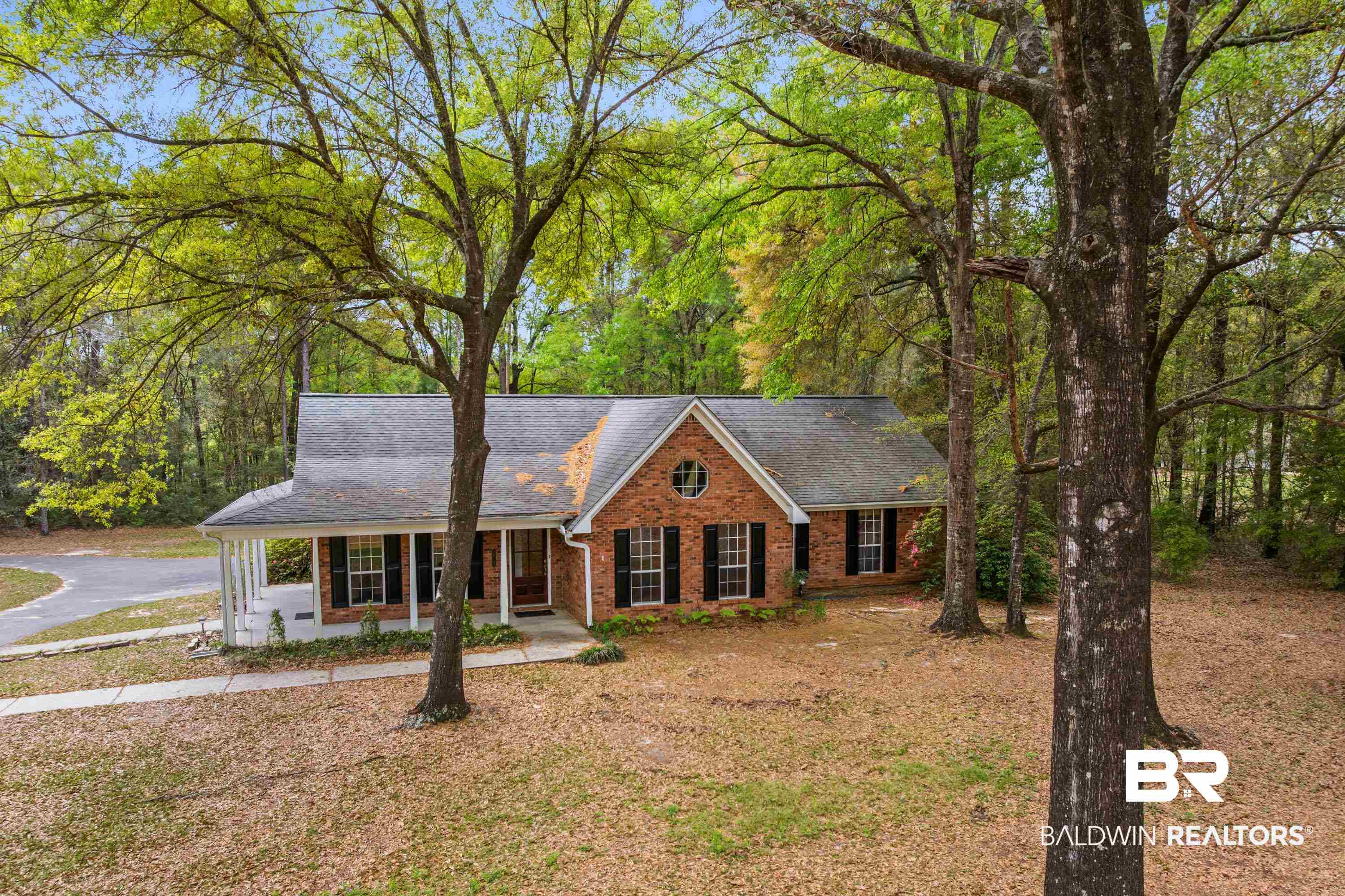 10140 Lakeview Road Bay Minette, AL 36507 - Photo 1 of 35 View of front facade featuring covered porch, a shingled roof, brick siding, and a front lawn
