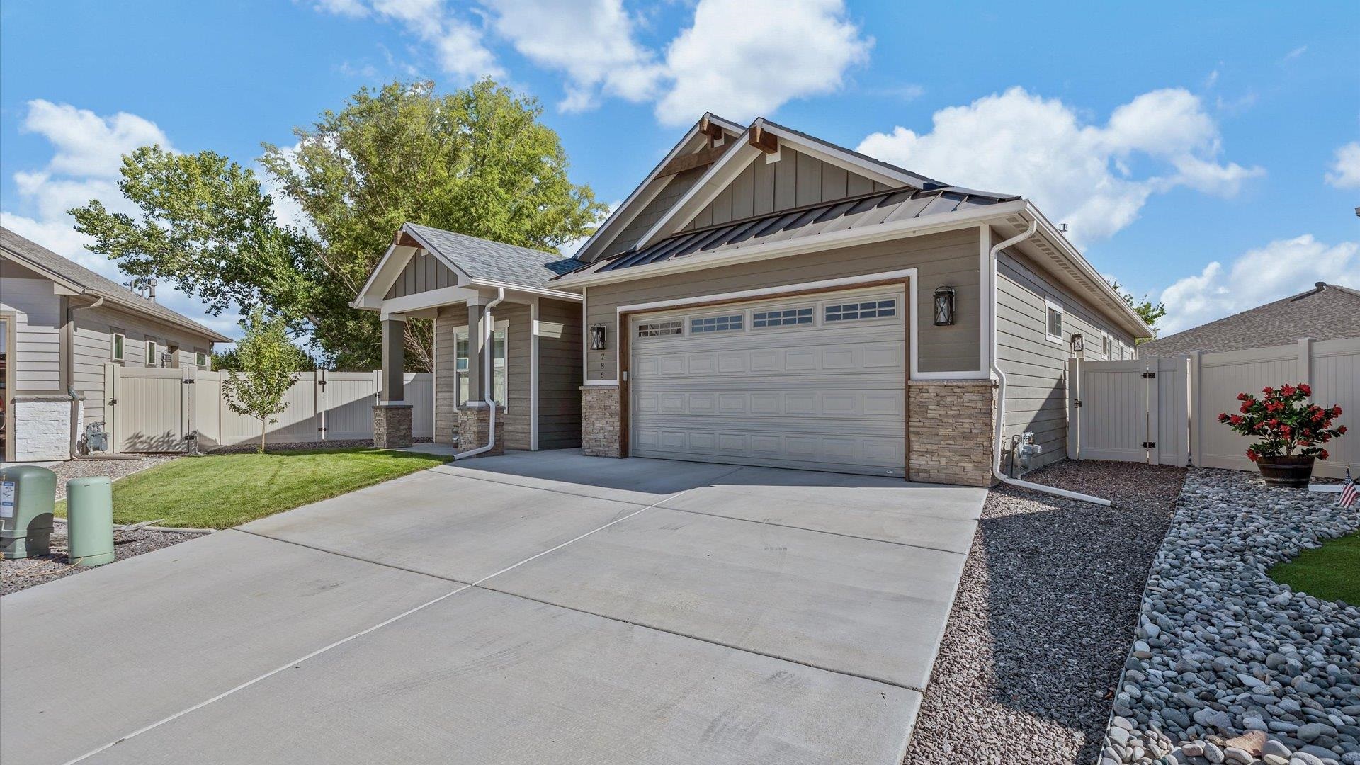 786 Spur Cross Road Grand Junction, CO 81505 - Photo 3 of 27 a front view of a house with a yard and garage