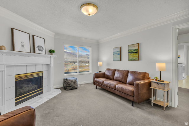1060 West 2620th Street South Mapleton, UT 84664 - Photo 33 of 87 Living area featuring crown molding, light carpet, a tile fireplace, and a textured ceiling