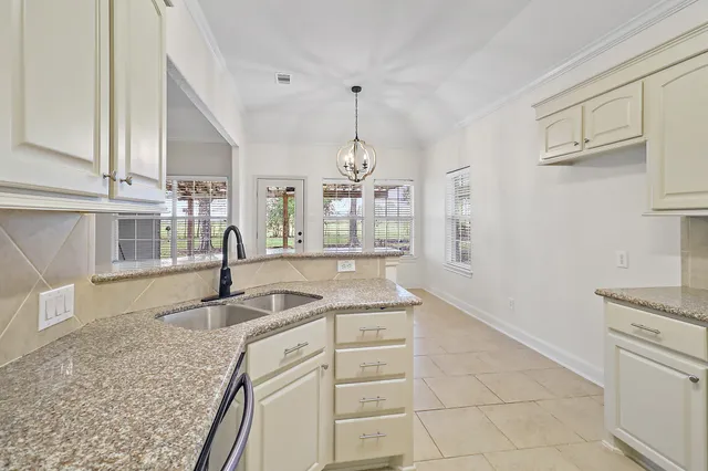 a kitchen with white cabinets and appliances