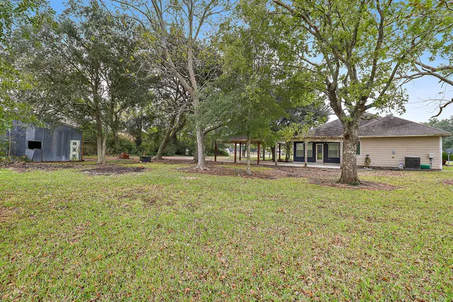 a house with a big yard with large trees