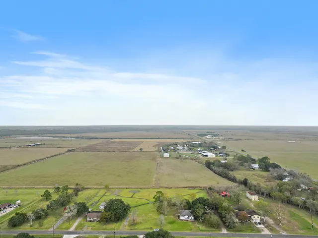 an aerial view of ocean and residential houses with outdoor space