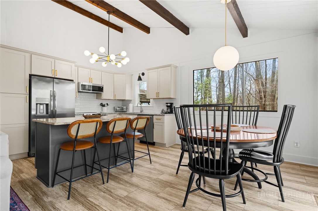 811 Pine Ridge Road Beech Mountain, NC 28604 - Photo 7 of 26 a dining room with furniture a chandelier and wooden floor