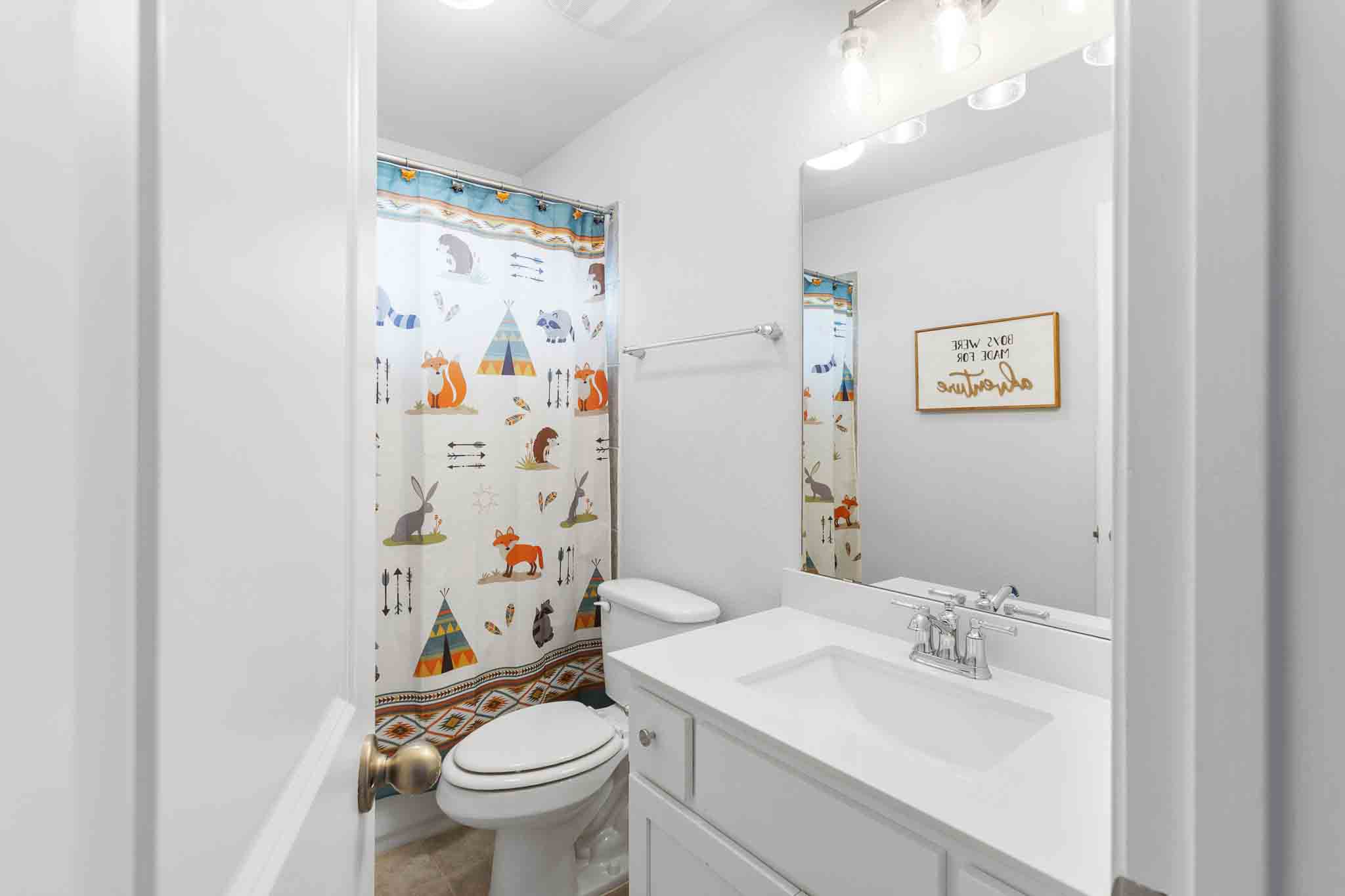 166 West Branch Road Kyle, TX 78640 - Photo 29 of 39 A well-lit, compact bathroom, offering essential amenities with a charming decorative touch.