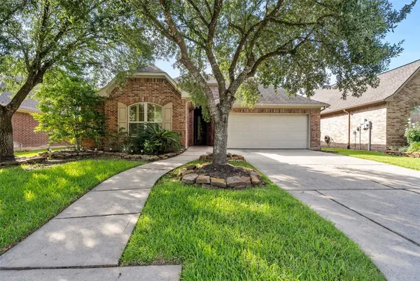 a front view of a house with yard and green space