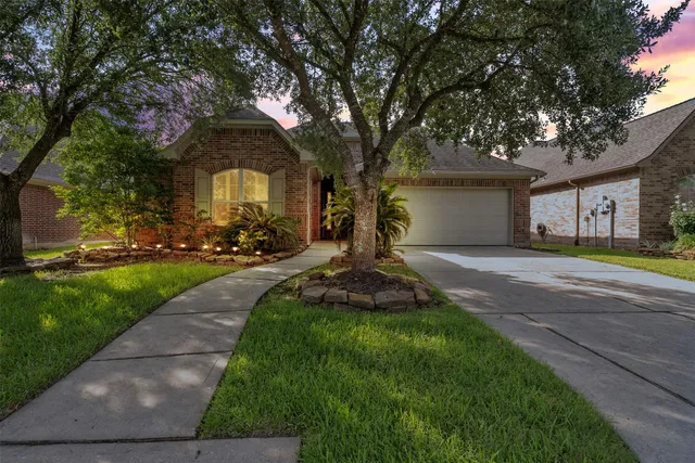 a front view of a house with a yard and trees
