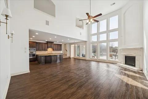 a view of an empty room with a fireplace and wooden floor