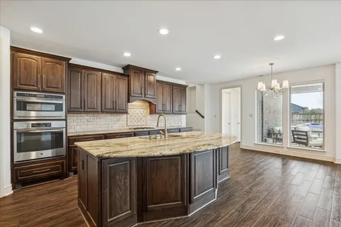 a kitchen with kitchen island granite countertop a stove and a sink