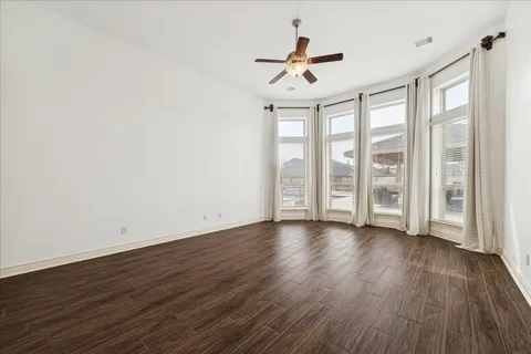 a view of room with wooden floor and ceiling fan