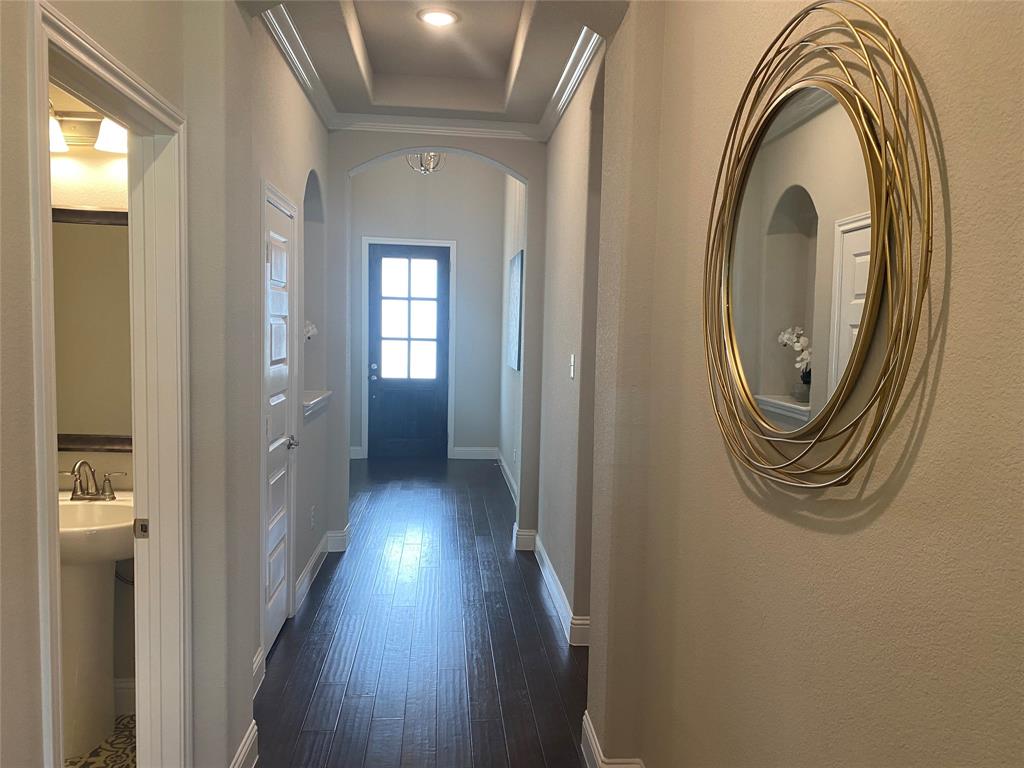 209 Johnson Street Granbury, TX 76048 - Photo 20 of 40 Corridor featuring ornamental molding, a tray ceiling, and dark wood-type flooring