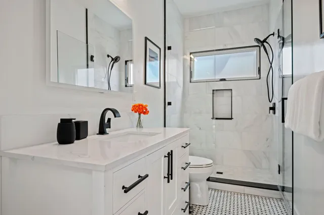 a bathroom with a sink a toilet and shower