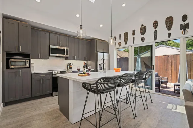 a kitchen with stainless steel appliances granite countertop a stove a sink a microwave a center island and a cabinets