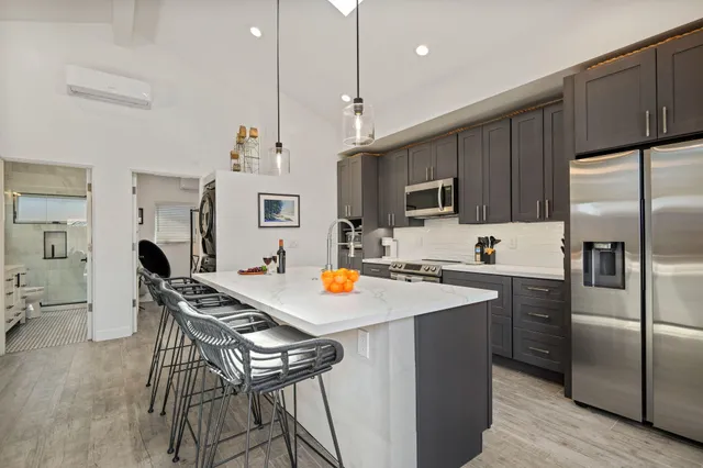 a kitchen with a refrigerator a stove a microwave oven a sink a dining table and chairs