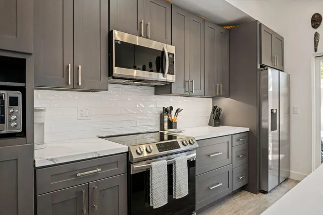 a kitchen with stainless steel appliances a sink stove and microwave