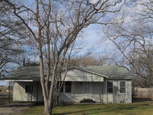 a front view of a house with a garden and tree