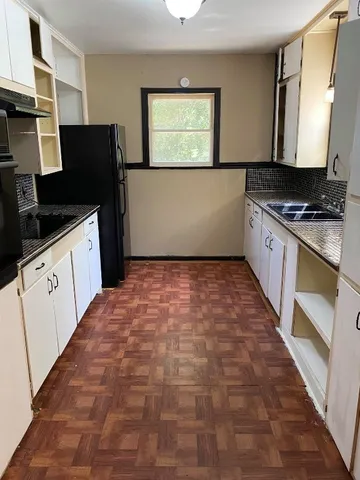 a kitchen with granite countertop a refrigerator and a stove