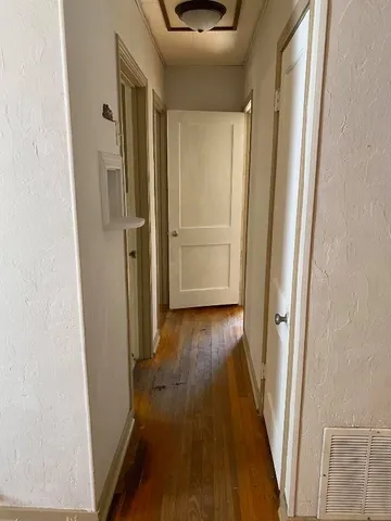 a view of a hallway with wooden floor and staircase