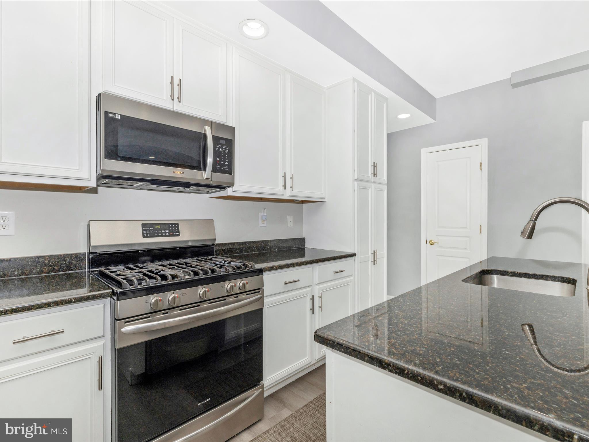 1813 Wheyfield Drive, Unit 10A Frederick, MD 21701 - Photo 15 of 50 a kitchen with granite countertop a sink stove and microwave