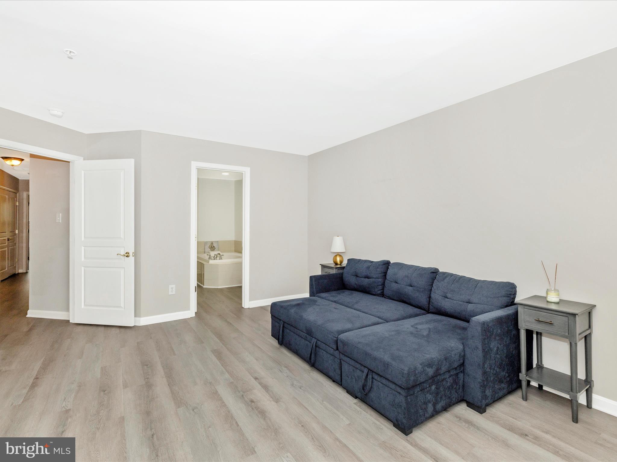 1813 Wheyfield Drive, Unit 10A Frederick, MD 21701 - Photo 18 of 50 a living room with furniture and a wooden floor