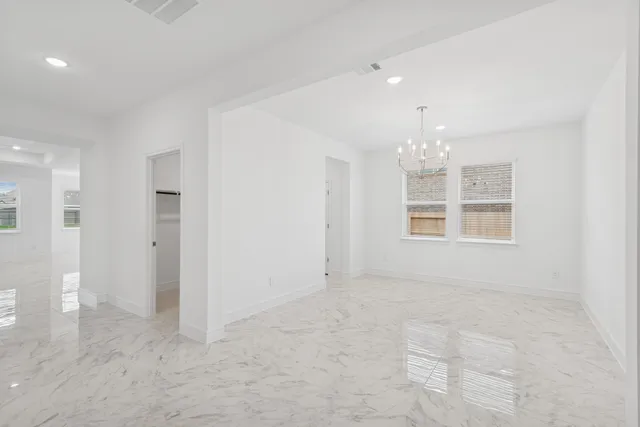 an empty room with chandelier and windows