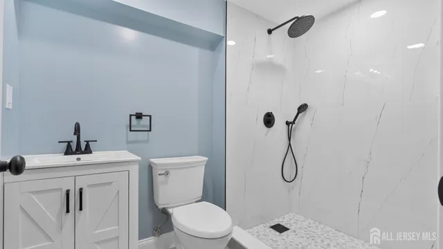 a bathroom with a sink a toilet and shower