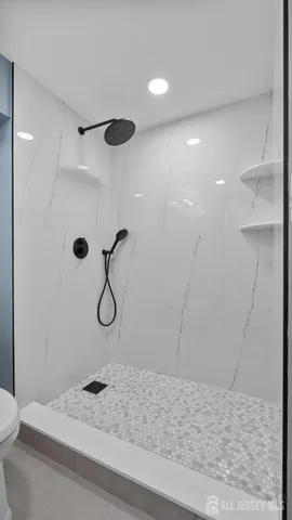 a bathroom with a granite countertop shower a sink and a toilet