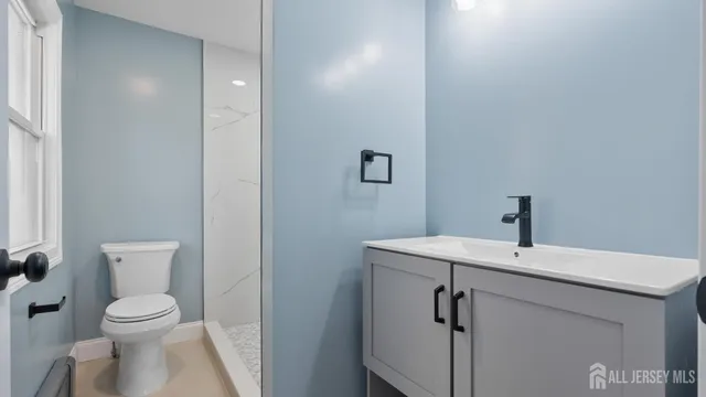 a bathroom with a sink a toilet and a mirror
