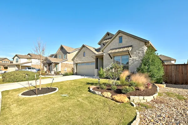 a view of a house with backyard and sitting area