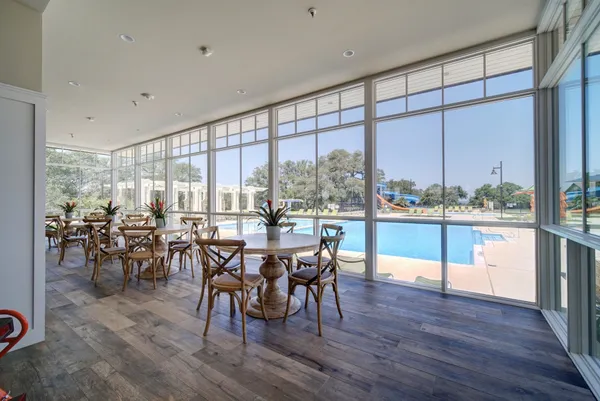 a view of swimming pool with lawn chairs and large tree