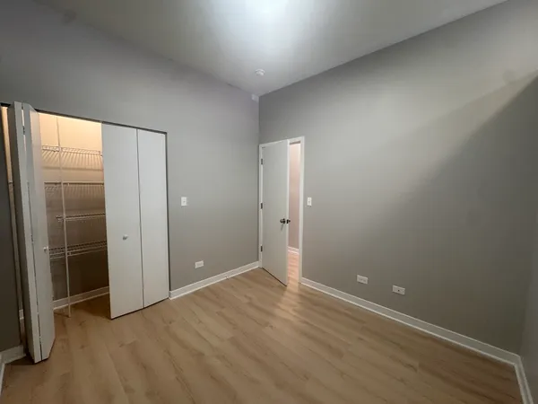 an empty room with wooden floor and door