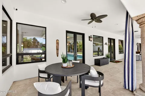a dining room with furniture and a floor to ceiling window