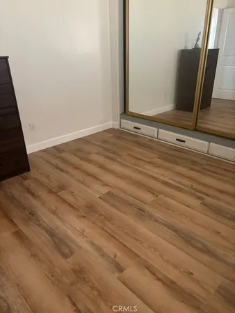 a view of a closet area with wooden floor