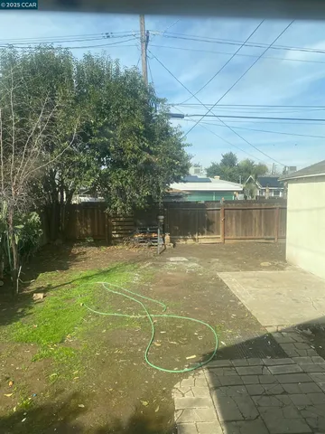 an empty room with wooden floor chandelier and windows