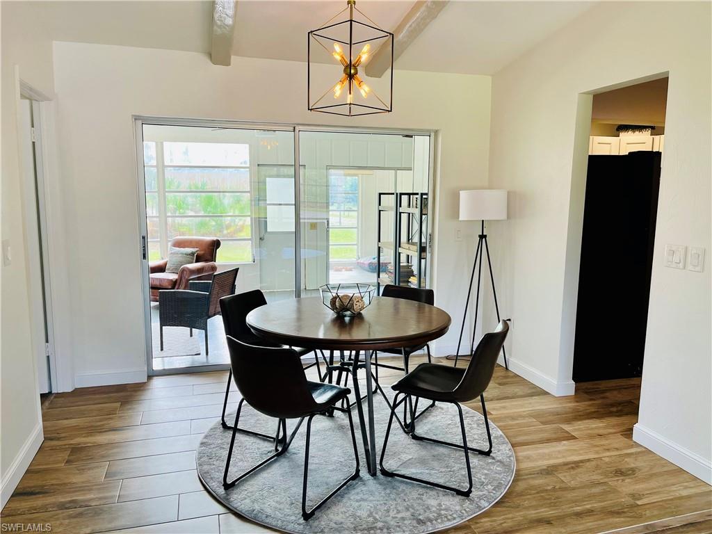 6730 Sable Ridge Lane Naples, FL 34109 - Photo 12 of 27 a view of a dining room with furniture and wooden floor