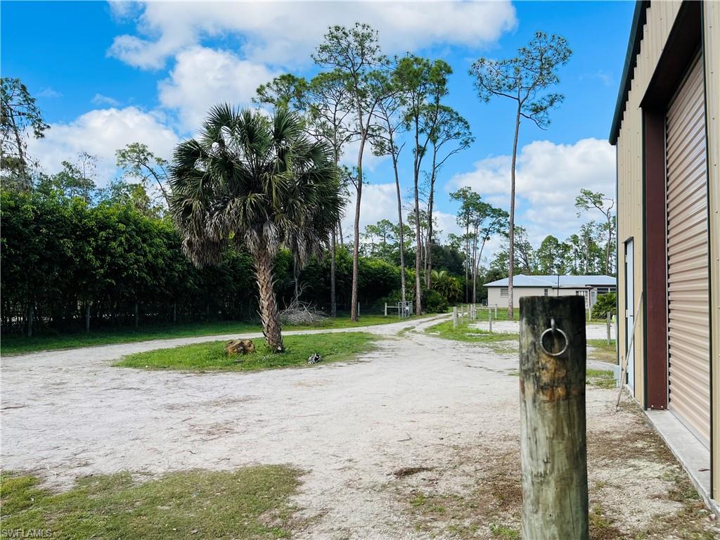 6730 Sable Ridge Lane Naples, FL 34109 - Photo 22 of 27 a front view of a house with garden