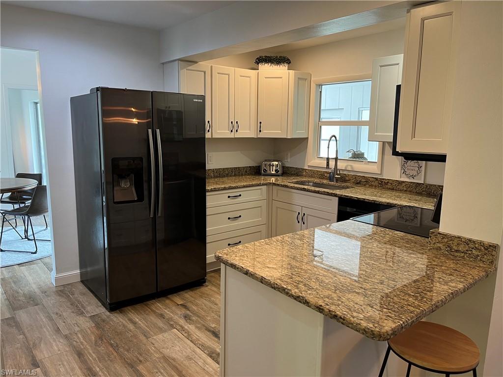 6730 Sable Ridge Lane Naples, FL 34109 - Photo 8 of 27 a kitchen with granite countertop kitchen island stainless steel appliances a refrigerator sink and cabinets